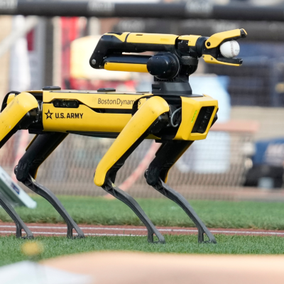 An Army robot that loosely resembles the shape of a dog on a turf field.