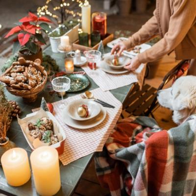 A dog looking at a Christmas dinner table.