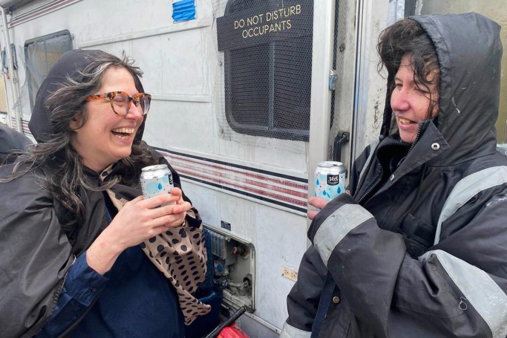 Sisters Julie Crossman, left, wearing glasses and smiling, and Nanie Crossman reunite outside of Nanie’s trailer in West Oakland, six years losing touch with each other.