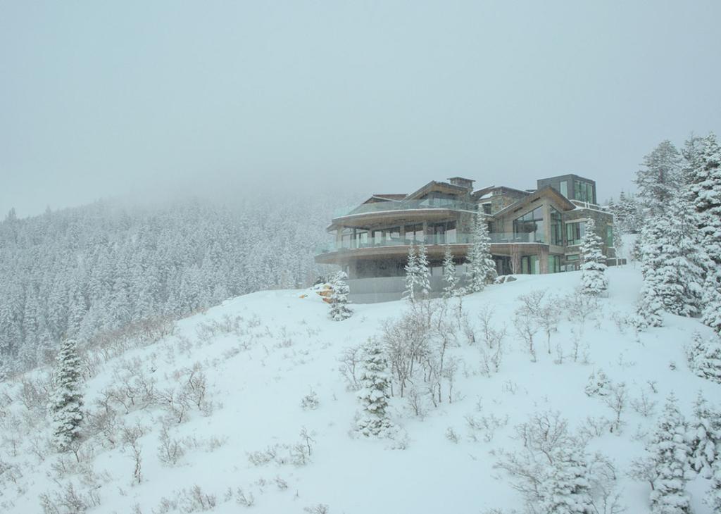 Snow covered hillside and exterior of mansion in an exclusive Park City development that was location for the show Mountainhead.