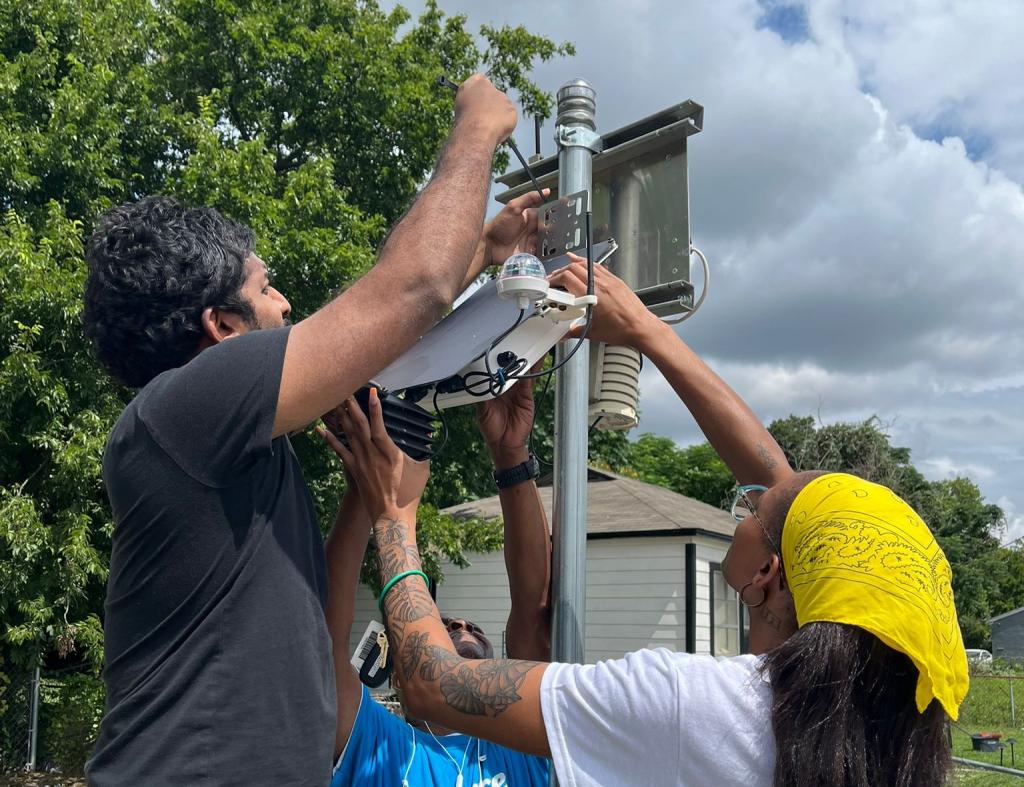 Lakitha Wijeratne, with the University of Texas at Dallas, left, and Alicia Kendrick, a community organizer with Downwinders at Risk, install air-monitoring equipment.