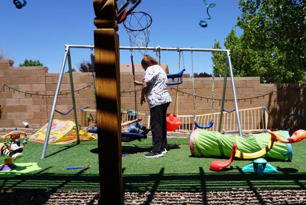 Maggi plays with a child in the back play yard of her child care program.