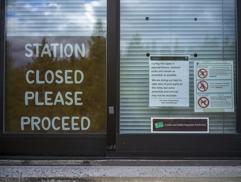 A 'Station Closed, Please Proceed' sign and staff note announcing they are doing their best during a government shutdown on October 14, 2025 in Grand Teton National Park, Wyoming. 