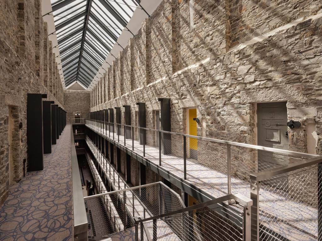 View of corridor with doorways of the rooms in the Bodmin Jail Hotel with a skylight above.