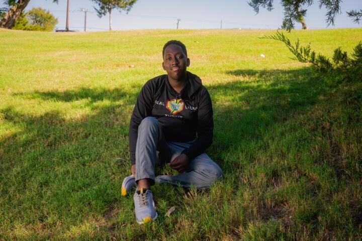 Portrait of Micah Clayborne, 15, a heart transplant recipient sitting in the grass at Lions Park in Ennis, Texas.