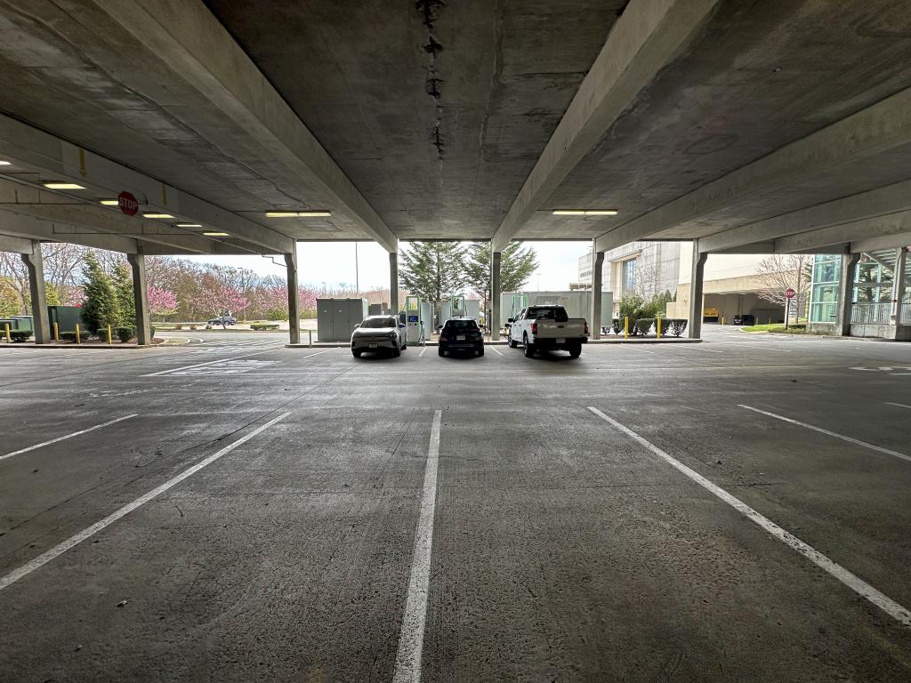 Three EVs charging at an Electricity America EV charging station in a parking garage in Boston. 