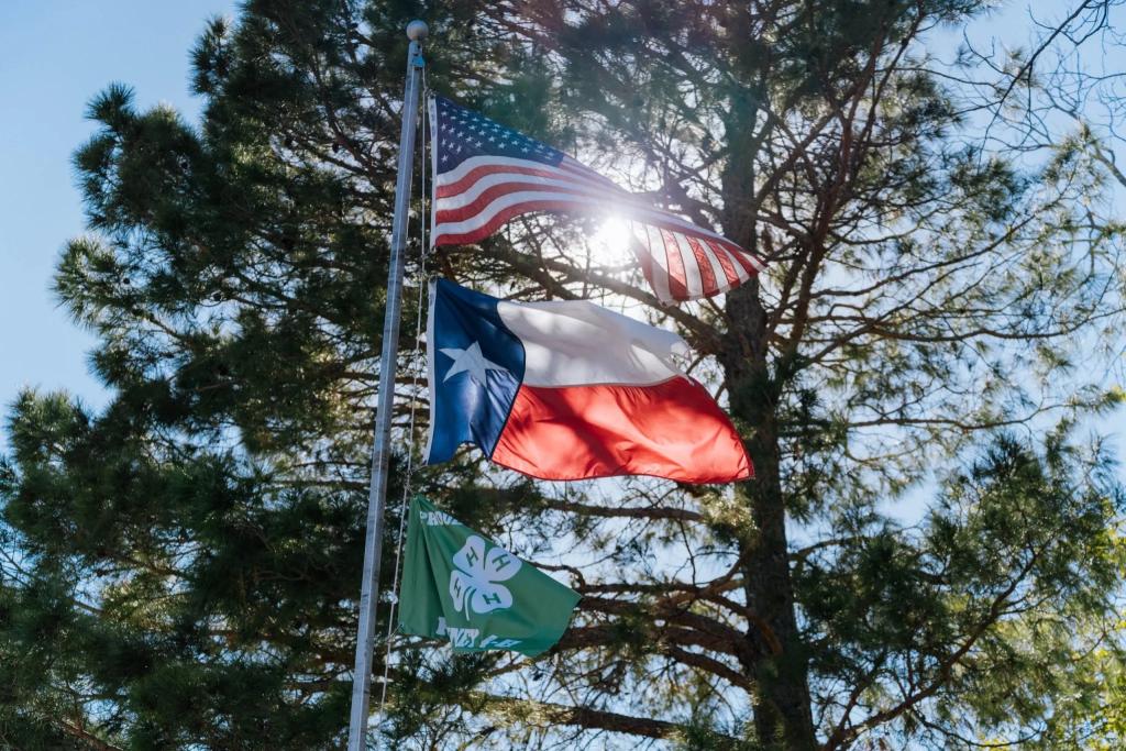 The American and Texas flags fly in Kinney County, Texas. A new Texas state law requires nearly every county sheriff to participate in the Section 287(g) program.