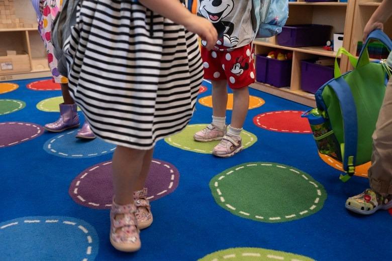 Children, whose faces are not visible, on a colorful rug at a transitional kindergarten class at Silverwood Elementary School in the Mt. Diablo Unified School District in Concord.