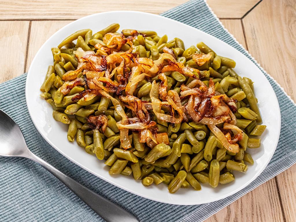 A plate of sautéed green beans with caramelized onions.