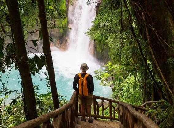 A tourist facing the Rio Celeste Waterfall in Costa Rica.