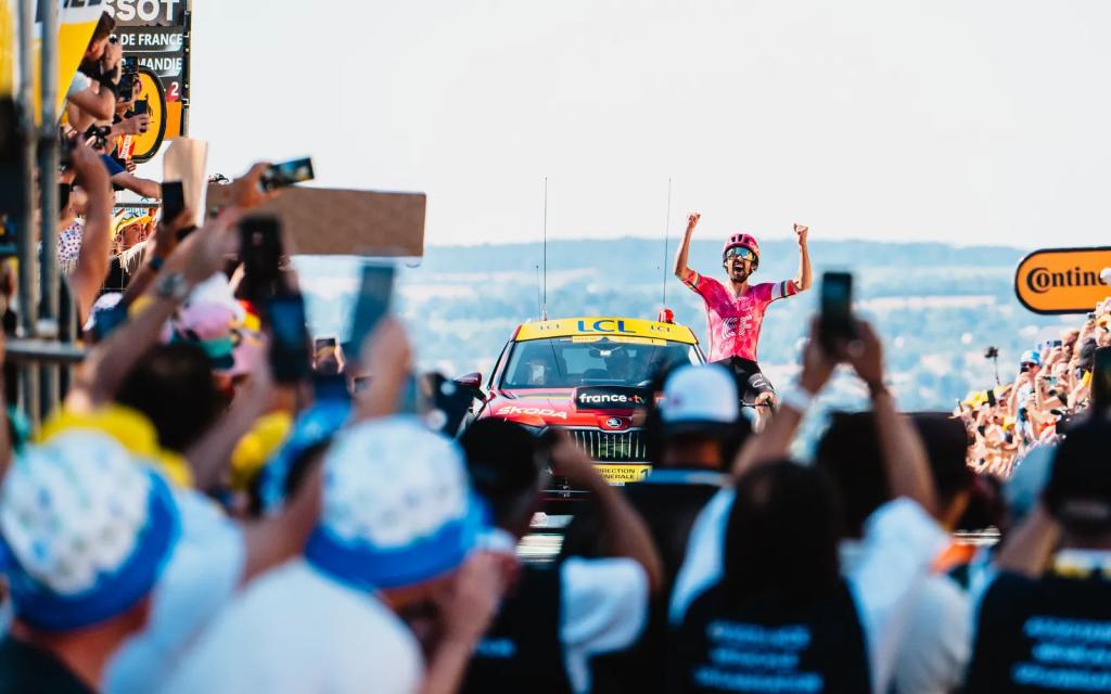 People cheer on a rider for Tour de France as they arrive at the finish line.