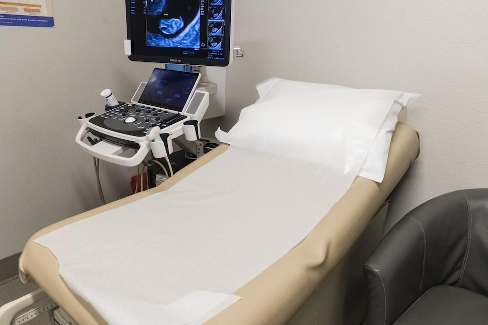 A bed and ultrasound unit in a pregnancy center, a part of life-affirming women's medical clinics operations.