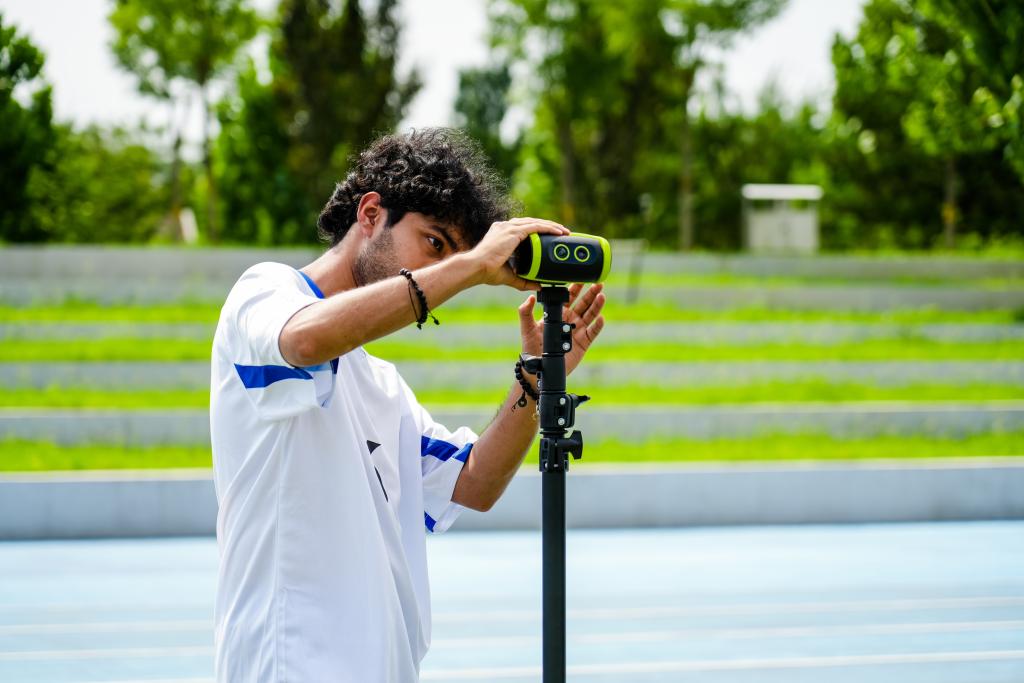A sports coach setting up a sports camera.
