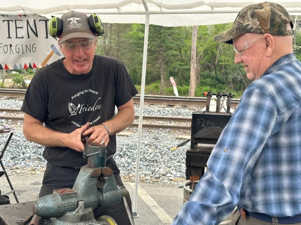 Utz (left) bends metal as part of a blacksmithing demonstration at the Fire on The Mountain Festival in Spruce Pine, North Carolina.