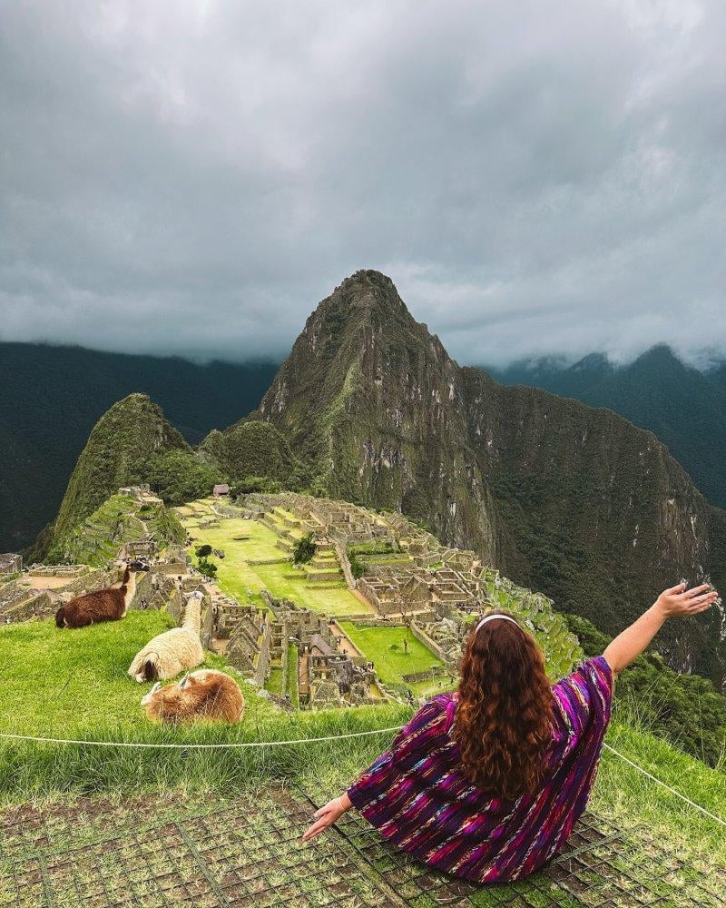A tourist overlooking the ancient Incan citadel of Machu Picchu in Peru.