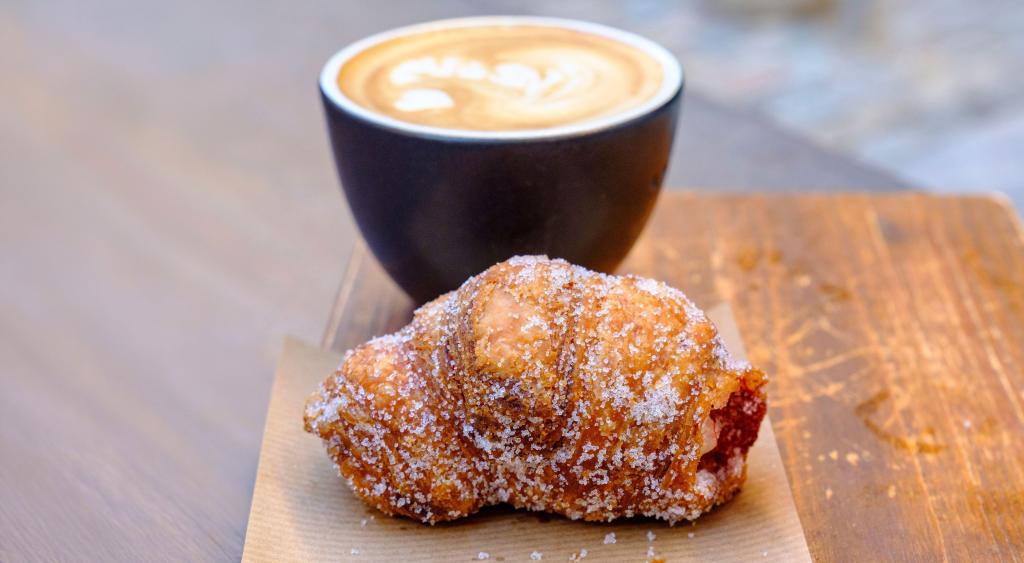 Xuixo, a traditional deep-fried Catalan pastry from Girona, and a cup of coffee.