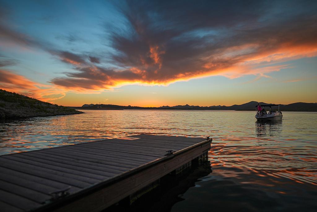 View of a boat reaching a dock during sunset in Lake Pleasant in Arizona.