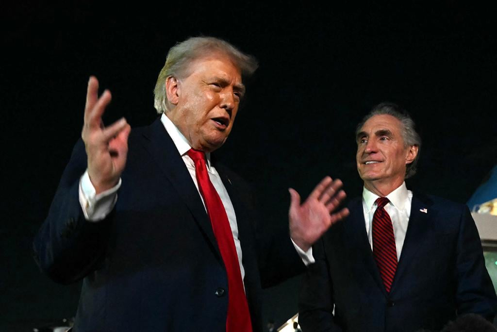 US President Donald Trump speaks with reporters as the Secretary of the Interior Doug Burgum (R) looks on, before boarding Air Force One at Palm Beach International Airport, in West Palm Beach, Florida on January 19, 2026. 