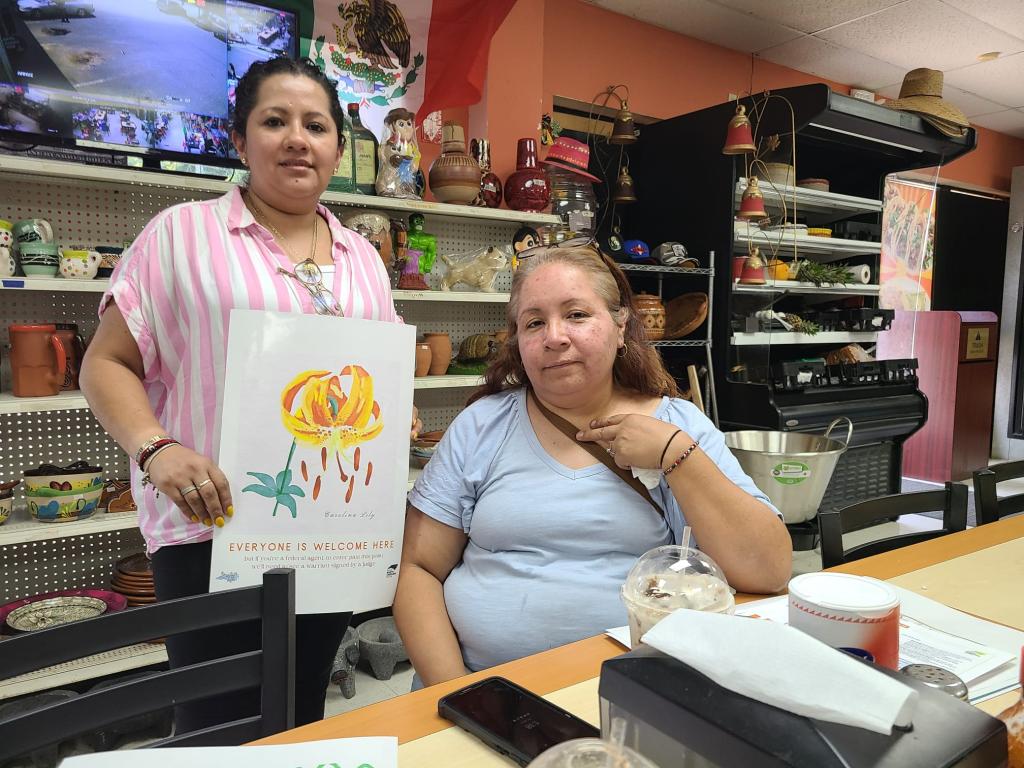Two people in a North Carolina business showing their 4th Amendment Workplace signage.