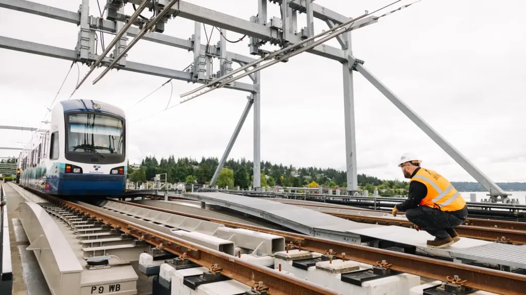 A worker crouches next to the tracks of a the $1 billion Crosslake Connection, an existing project that was behind schedule which Sound Transit aimed to finish before the world cup.