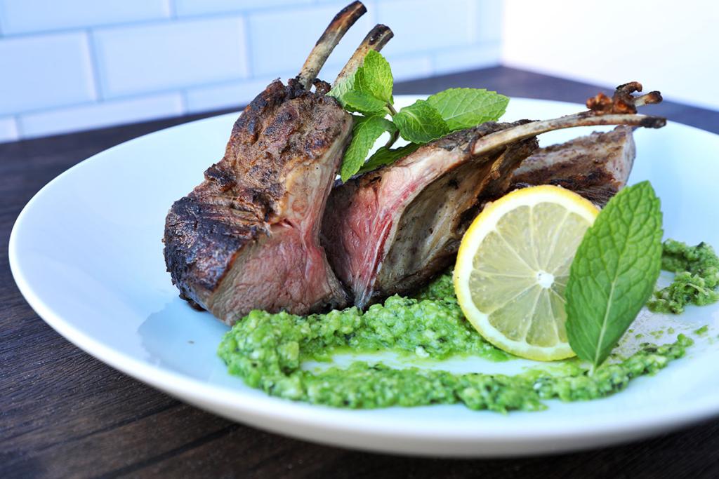 A plate of grilled lamb with pea and mind pesto.