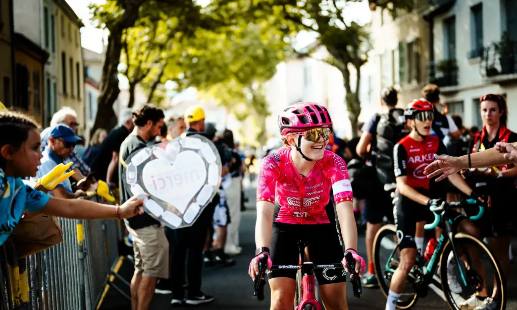 Fans cheering on cyclists along the barriers during the Tour de France Femmes avec Zwift.