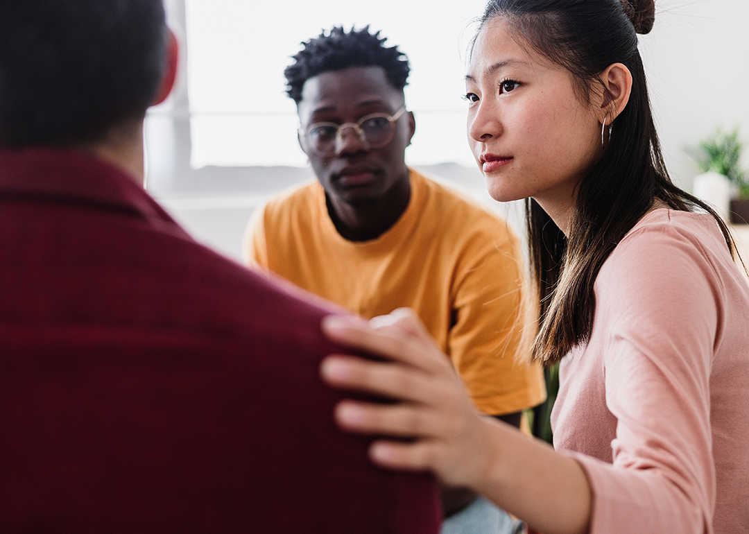 People in a group therapy session supporting each other.