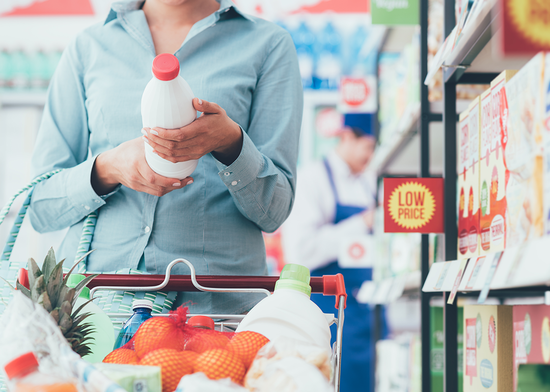 A person reading a food label in a supermarket.