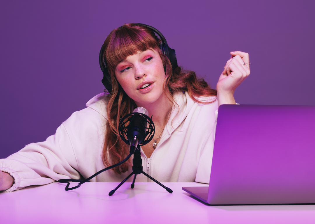 Podcaster recording an audio broadcast in neon purple light.