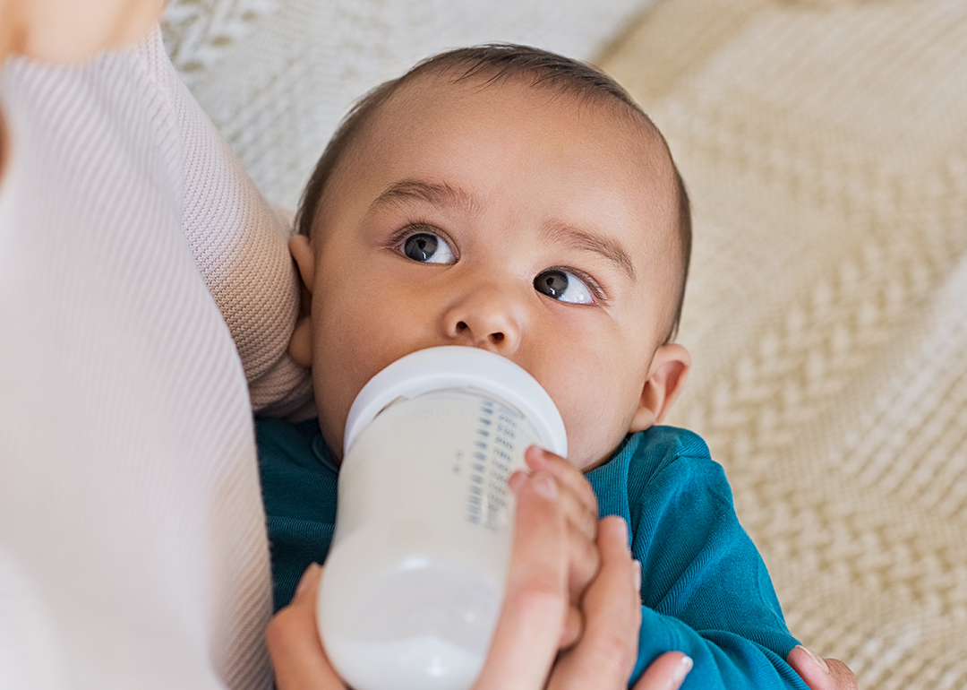 Mother feeding baby with bottle.