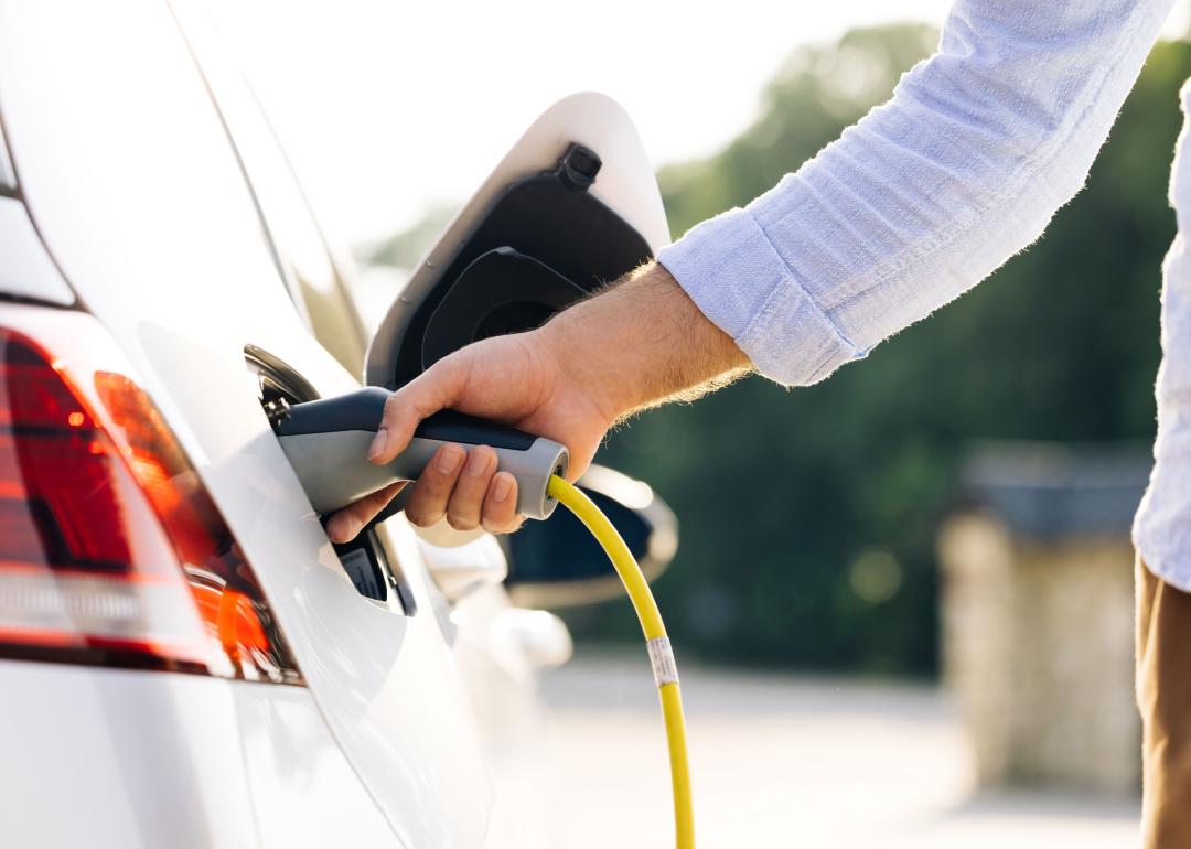 Person fueling hybrid car.