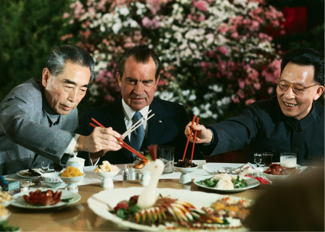 President Nixon eats with Premier Chou En-lai and Chang Chun-chiao at a farewell banquet.