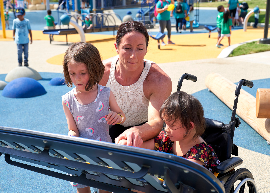Woman and children at a universally accessible playground