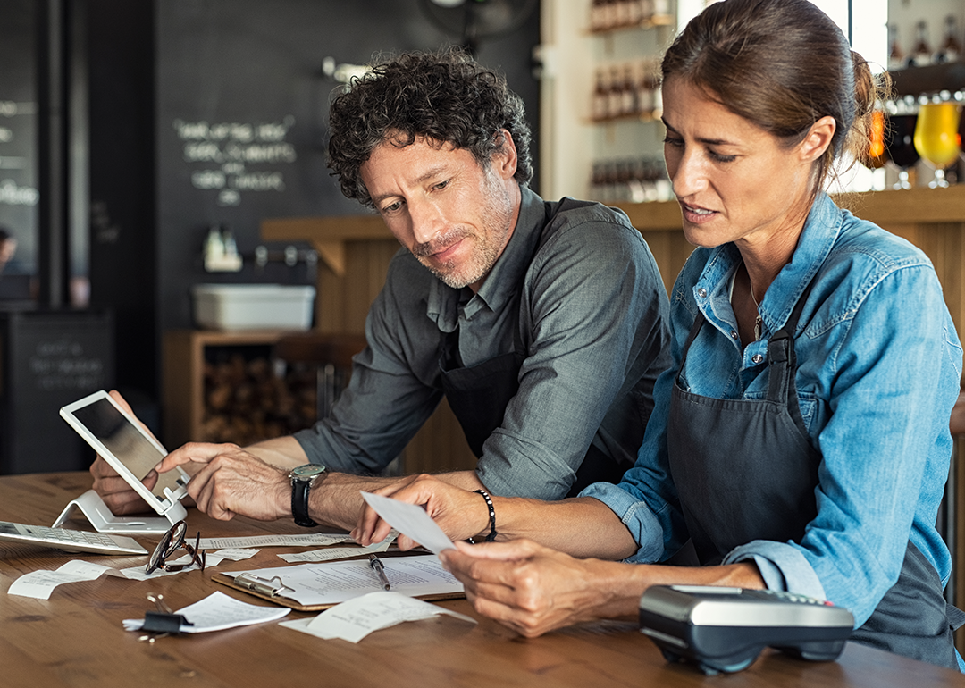 Cafe owners looking at bills and reports.