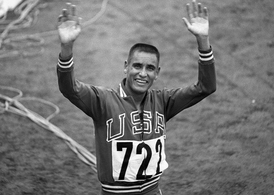 Billy Mills waving and smiling after winning the 10,000 meter race.