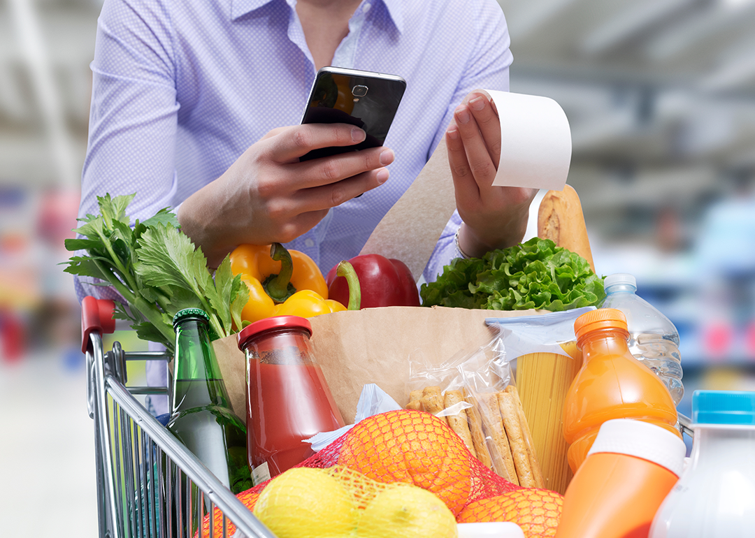 Woman checking the grocery receipt using her smartphone.