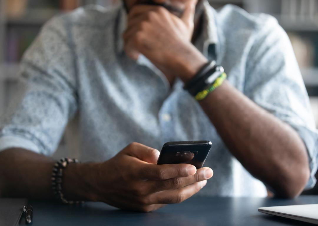 Cropped view of man holding phone.