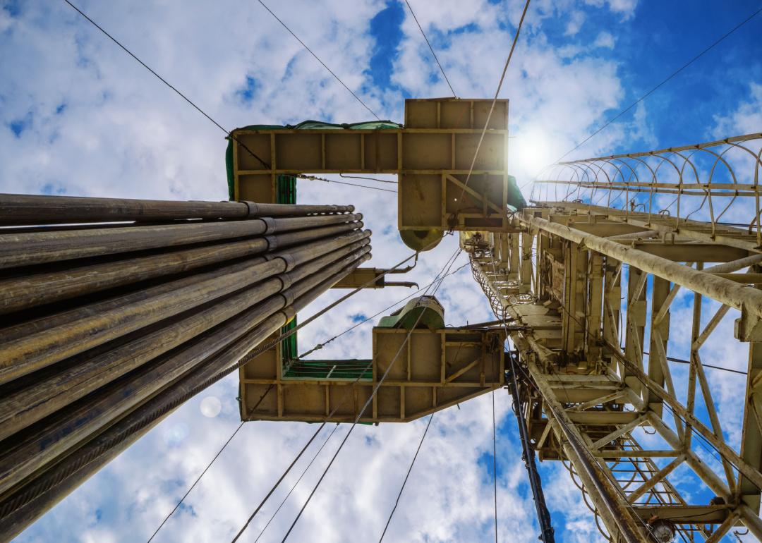 Looking up at cloudscape through gas drilling rig