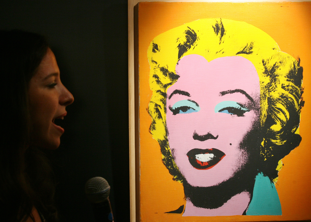 Christie’s employee stands with Orange Marilyn.