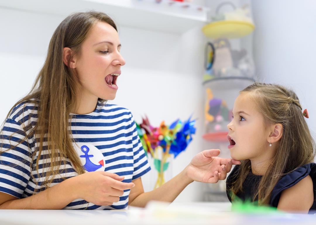 Preschooler practicing correct pronunciation with a speech therapist.