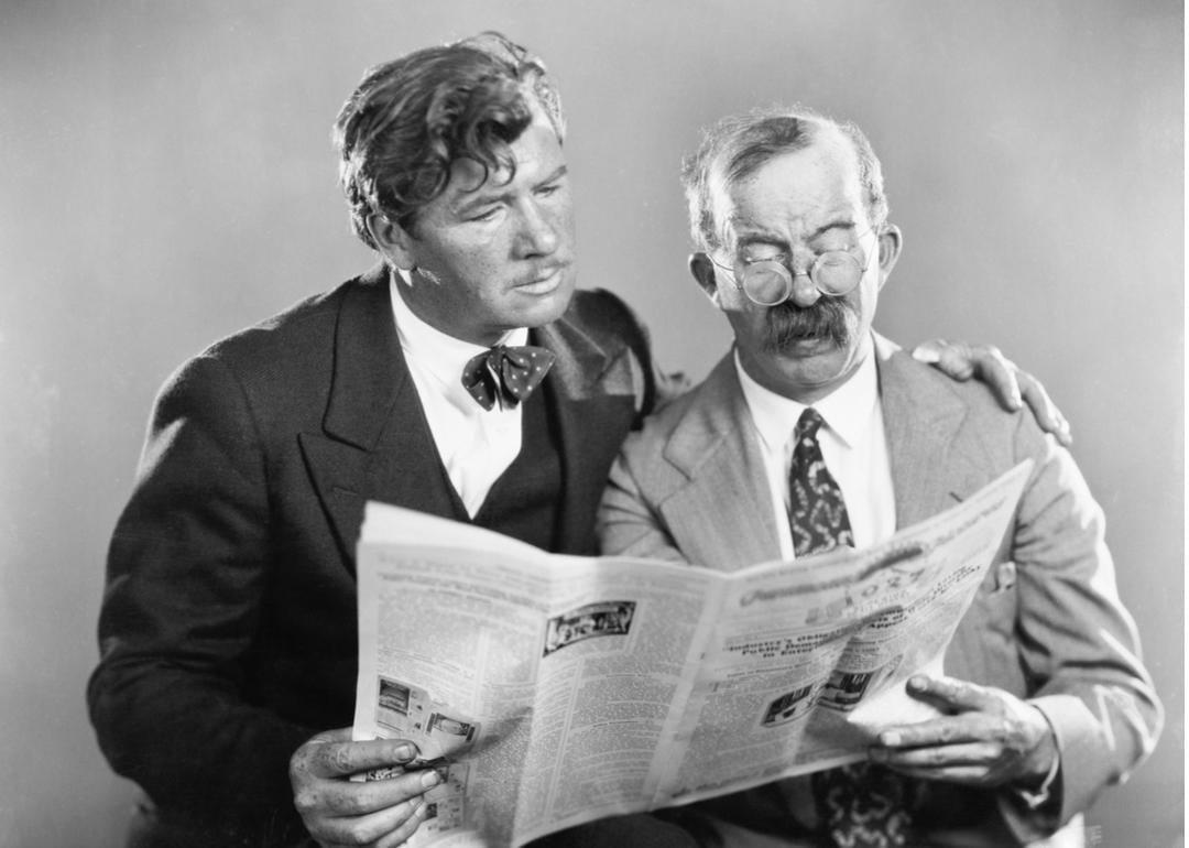Vintage photo of two men reading a newspaper together