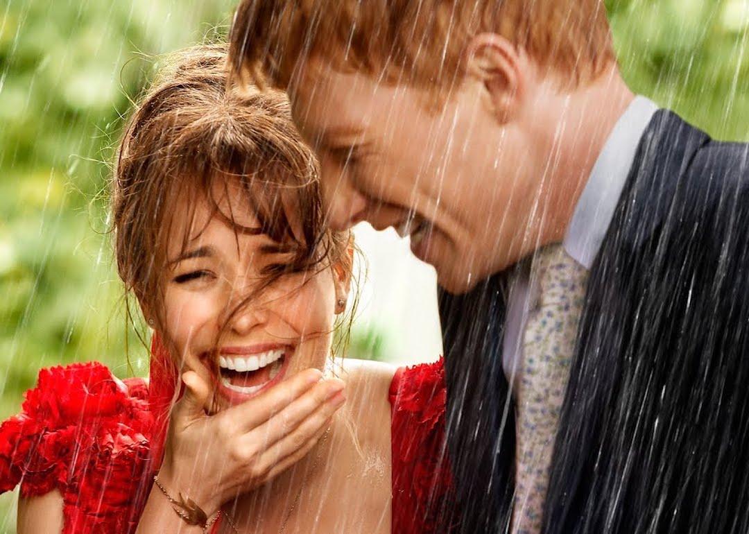 Rachel McAdams and Domhnall Gleeson laughing in the rain in "About Time."