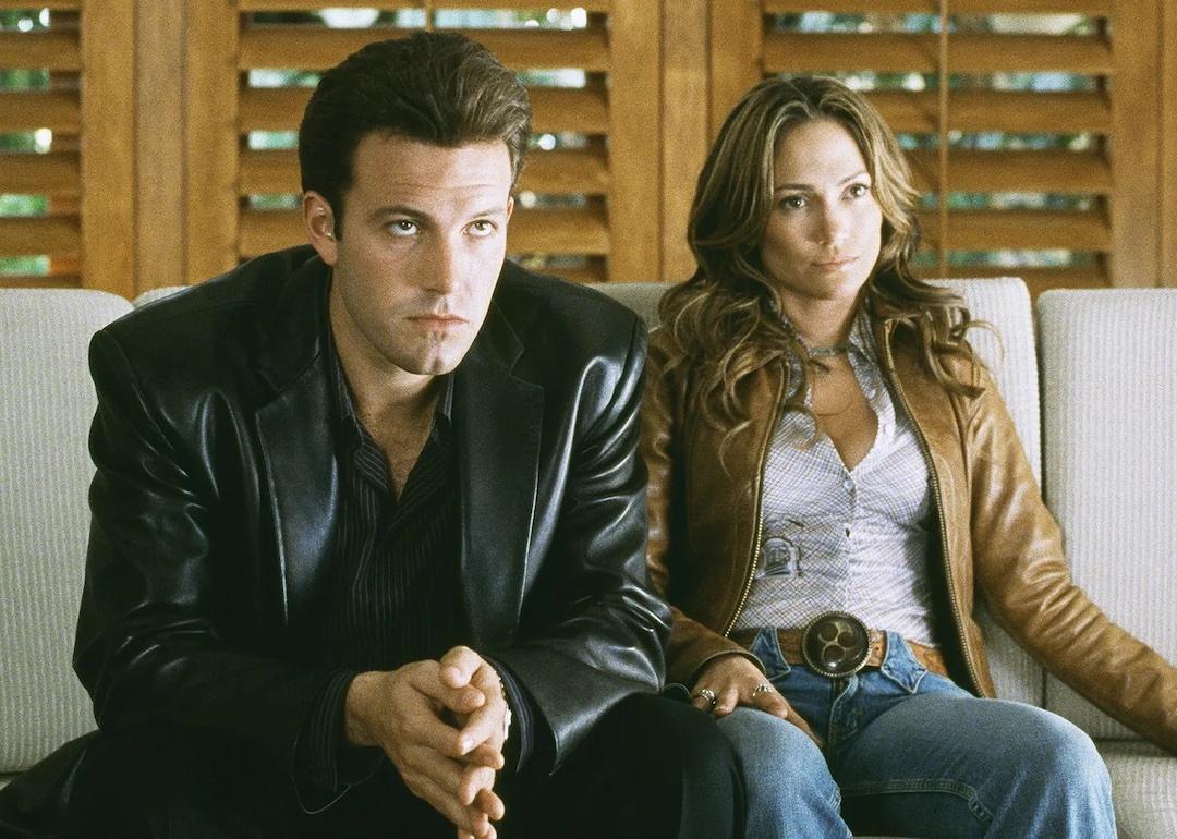 Ben Affleck and Jennifer Lopez sit on a couch as Larry Gigli and Ricki in 2003's "Gigli."