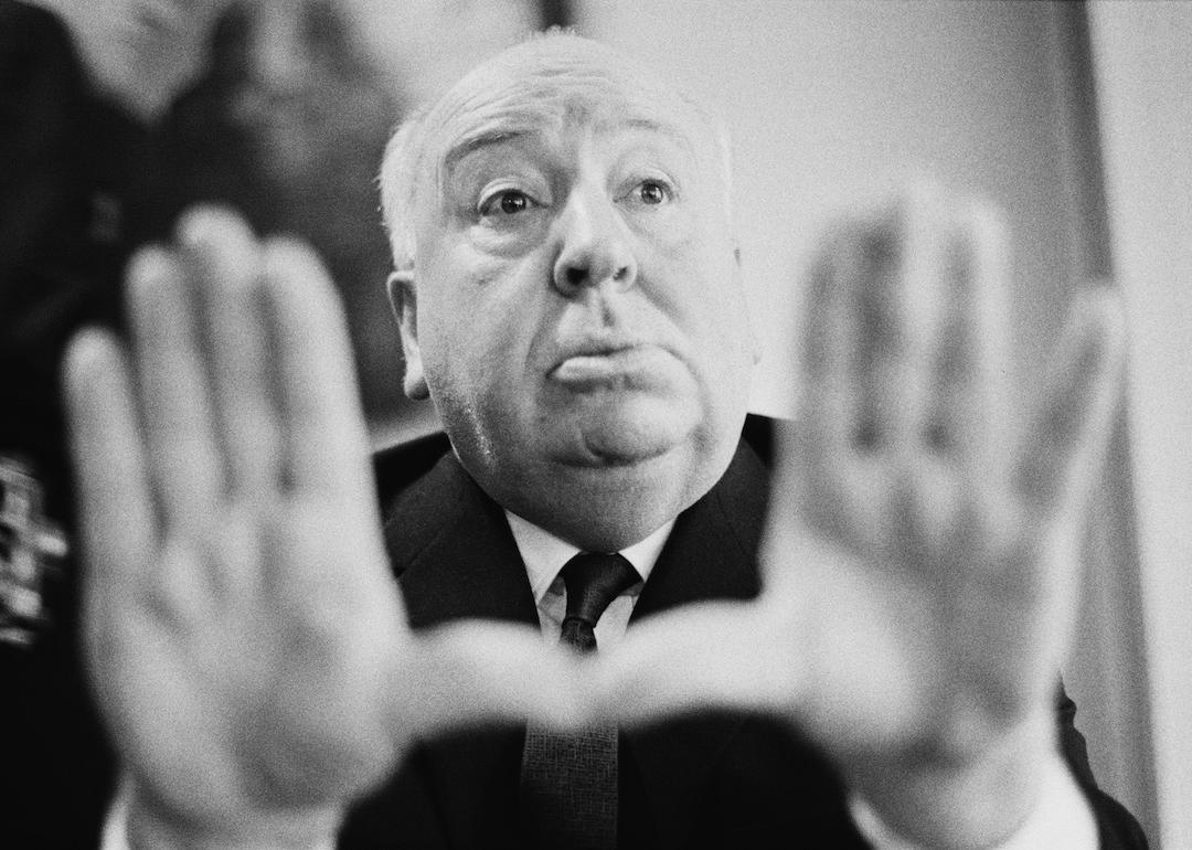 Director Alfred Hitchcock frames a shot with his hands.