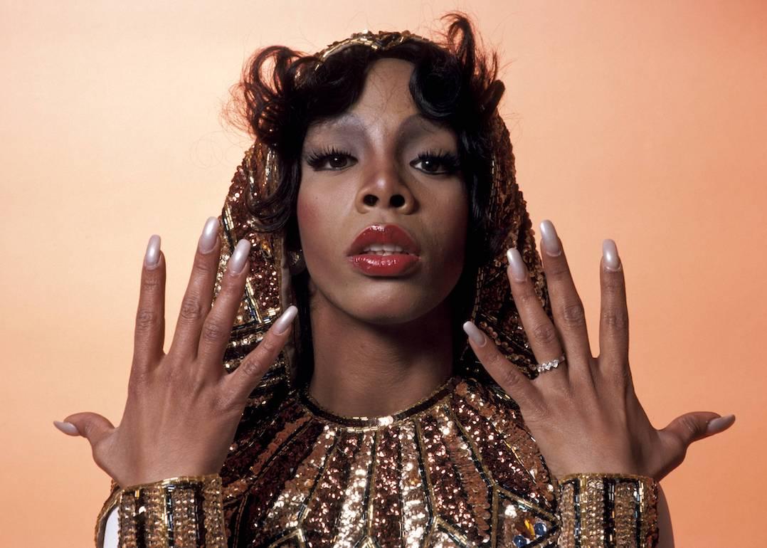 Donna Summer wears a sequined hooded outfit and shows off her nails in a 1976 portrait.