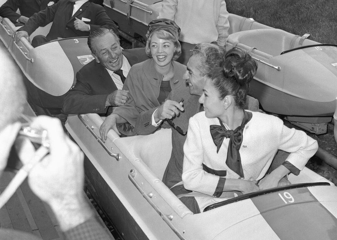 Enjoying the bobsled ride at Disneyland are the Shah of Iran and Empress Farah (in front of sled) and their host Walt Disney with a Disneyland hostess, Donna Jackson.
