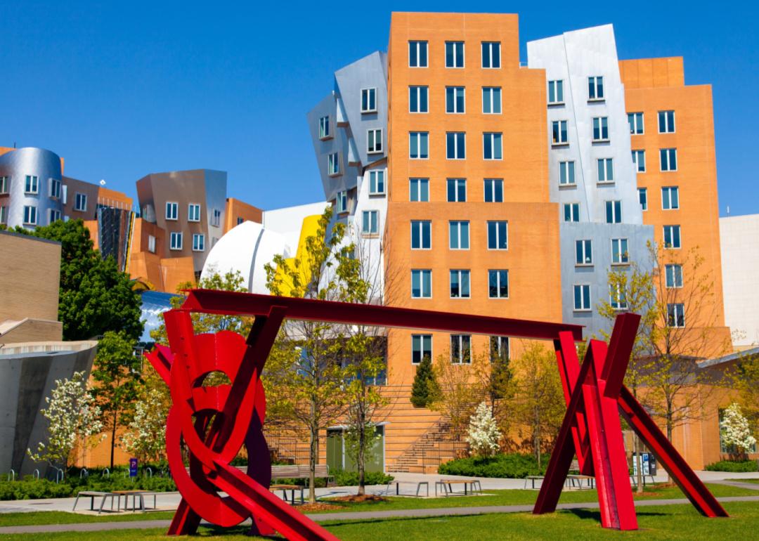 Red metal sculpture by artist Mark di Suvero and the iconic Stata Center by architect Frank Gehry on the MIT campus in Cambridge, Massachusetts.