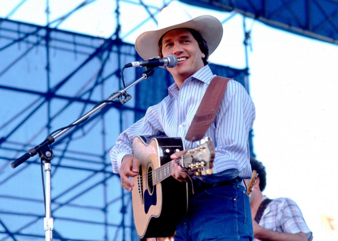 American Country musician George Strait playing guitar as he performs onstage at Chicagofest in 1985.