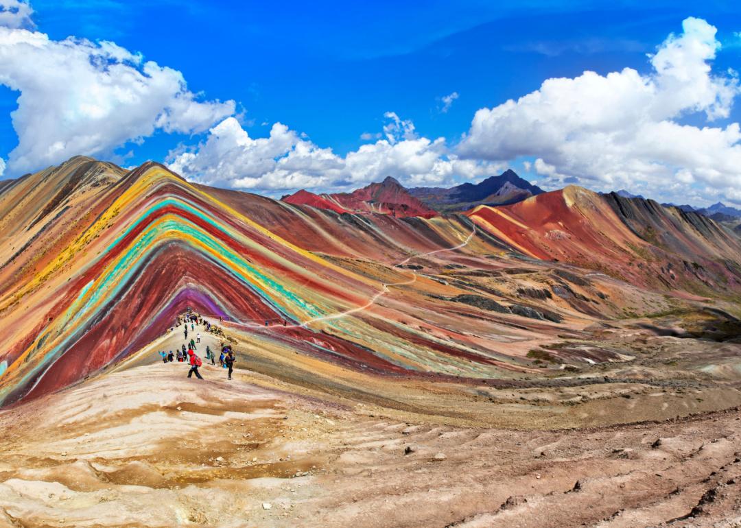 Tourists walking on the Rainbow Mountain (Vinicunca Montaña de Siete Colores) in Cusco, Peru.