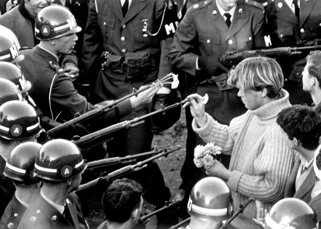 George Harris sticks carnations in gun barrels during an antiwar demonstrator at Pentagon in 1967.